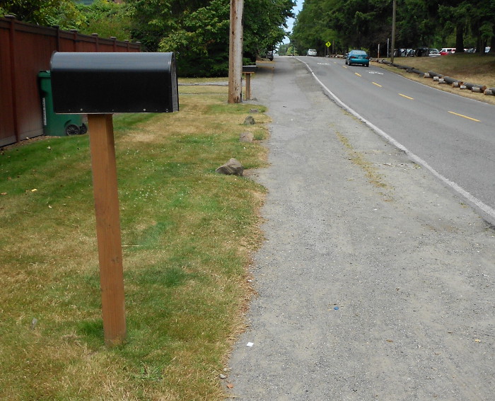 Photo of sidewalk partially obscured by gravel